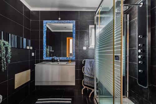 a black bathroom with a sink and a mirror at Casa d' Ana in Sesimbra