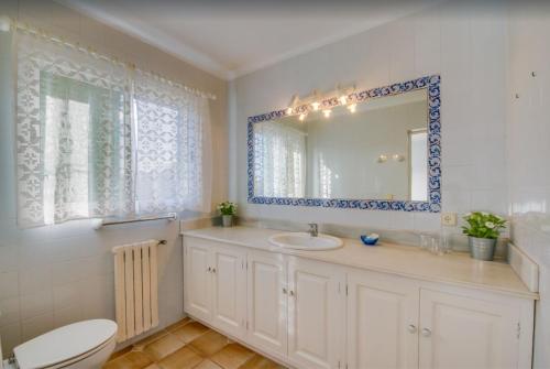 a bathroom with a sink and a toilet and a mirror at Algueret in Portopetro