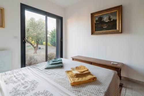 a bedroom with a bed with a picture and a window at Villa Helychrisa in Aléria