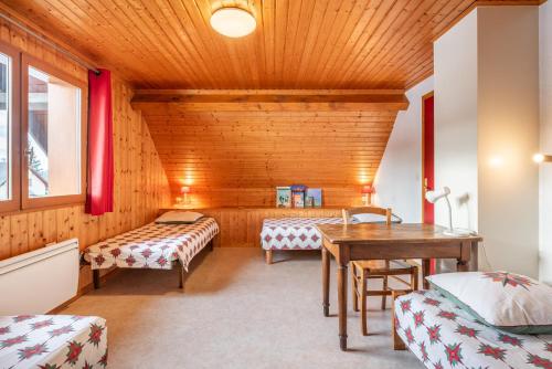 a room with two beds and a wooden ceiling at Chartrousin in Saint-Hilaire