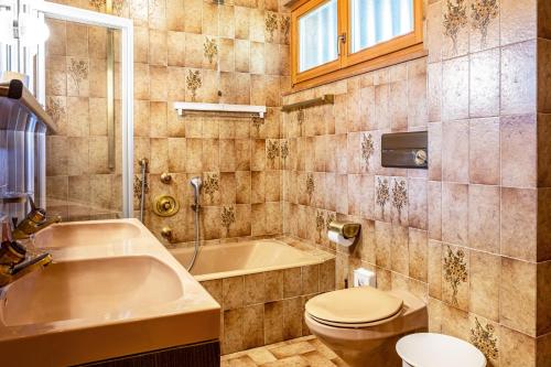 a bathroom with a tub and a toilet and a sink at Cesa Soramurat Appartamento 4 in Canazei