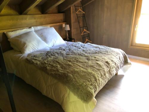 sypialnia z łóżkiem z białą pościelą i poduszkami w obiekcie Chalet L'envers w mieście Champagny-en-Vanoise