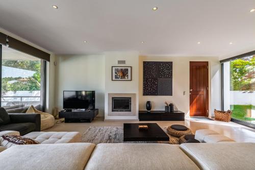 a living room with a couch and a tv at Casa Praia do Meco in Sesimbra