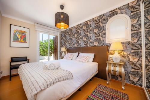 a bedroom with a large white bed and a stone wall at Finca Es Pi in Llucmajor