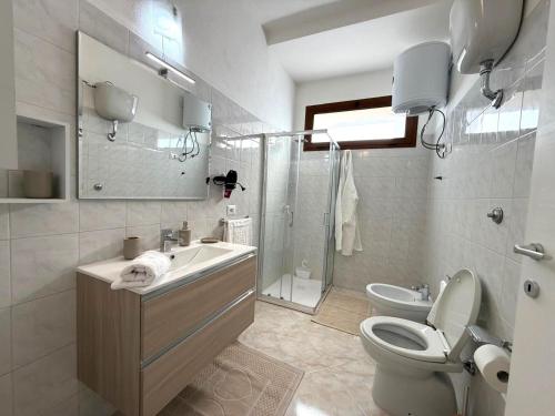 a bathroom with a toilet and a sink and a shower at Domus Teresa in Capoterra