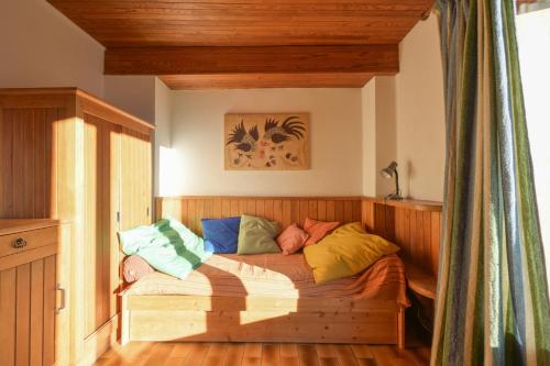 a bed with colorful pillows on it in a room at Chalet Paisible in Bourg-Saint-Maurice