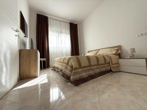 a white bedroom with a bed and a window at Domus Teresa in Capoterra