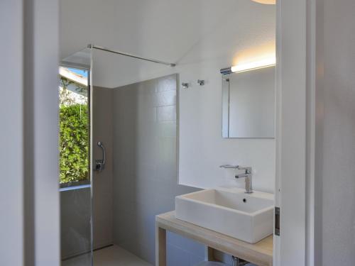 a white bathroom with a sink and a mirror at Villa Bua in Costa Rei