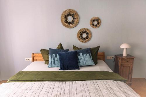 a bedroom with a bed with blue pillows and mirrors at Ferienwohnung am Schlossplatz in Wolfegg
