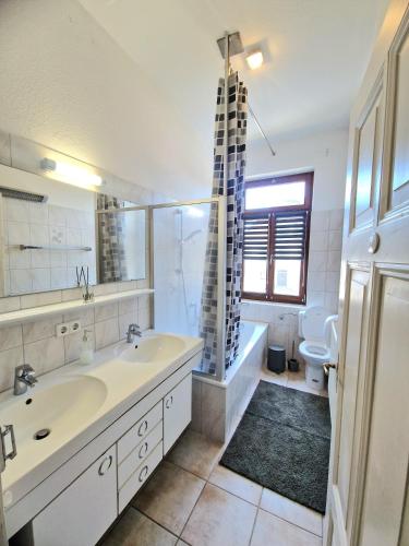 a bathroom with a sink and a tub and a toilet at Ferienwohnung am Schlossplatz in Wolfegg
