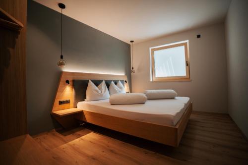 a bedroom with a bed with two pillows and a window at Aktiv Lodge Meran - Terrace Two in San Martino