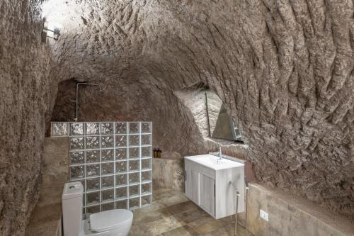 a stone bathroom with a toilet and a sink at Casa Efrén in Garafía