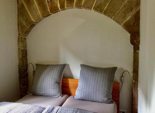 a bedroom with a bed with two pillows on it at Villa Buselmeier in Neuried