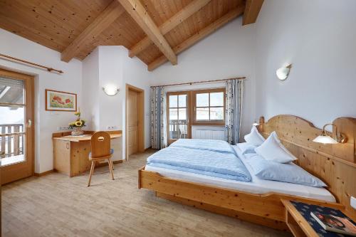 a bedroom with a large bed and a desk at Humblhof in Lagundo