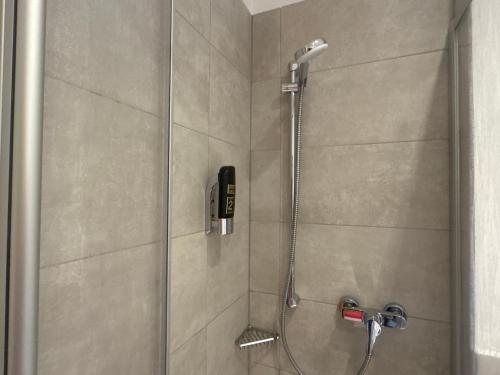 a shower with a phone in a bathroom at Hotel Rusticone Hechendorf in Seefeld