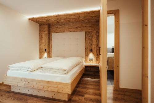 a bedroom with a bed with a wooden frame at Chalet La Flüta Viola in La Valle