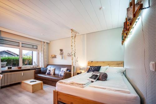 ein Schlafzimmer mit einem Bett und einer Couch in einem Zimmer in der Unterkunft Q-stadl in Steibis