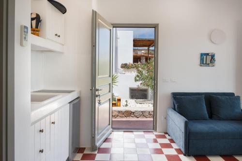 a kitchen with a blue chair and a sliding door at Luna Rossa Milos - Moon Kiss in Provatas