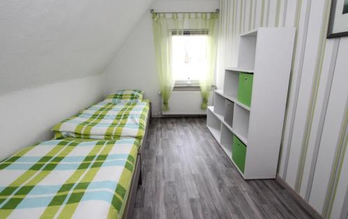 a small room with two beds and a window at Ferienhaus Olenbrook in Cuxhaven