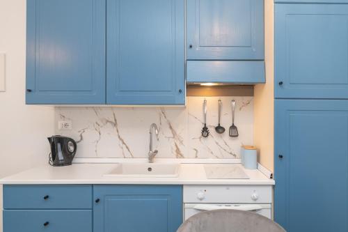 a kitchen with blue cabinets and a sink at Appartamento Palau Alba in Palau