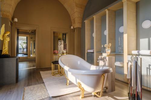 a large bathroom with a tub in a room at Maison Boutique At Daniela in San Pietro in Lama