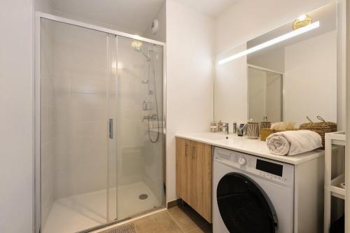 a bathroom with a shower and a washing machine at Cocon Terrasse près du Port - A102 in Pornic