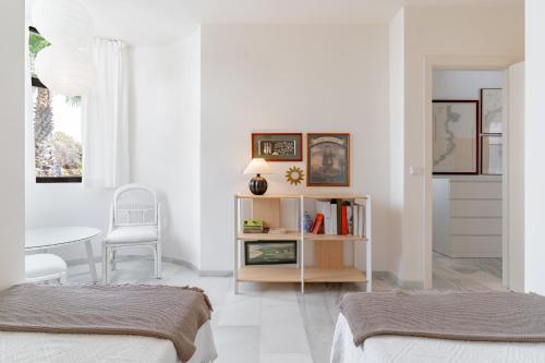 a white room with two beds and a table at Ganso golf in Benalmádena