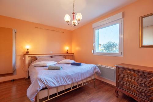 a bedroom with a bed and a window and a dresser at Villa Green in Saint-Amé