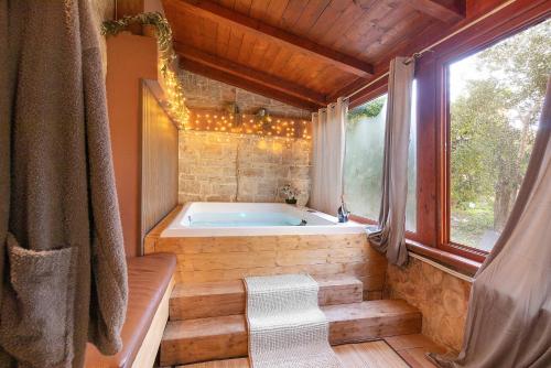 a bath tub in a room with a window at Apulia Luxury House in Toritto