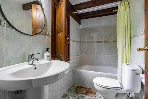 a bathroom with a sink and a toilet and a tub at Casa Rural Ricao in Cangas de Onís