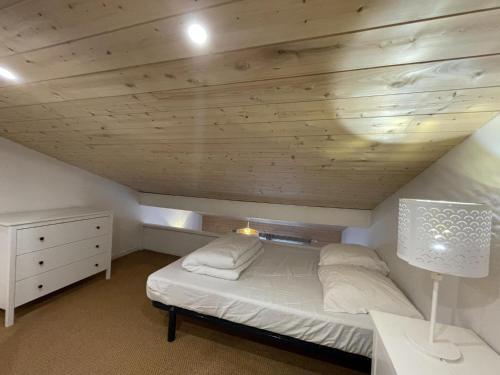 a bedroom with a bed and a wooden ceiling at La Tomate Surfeuse 2 in Hourtin