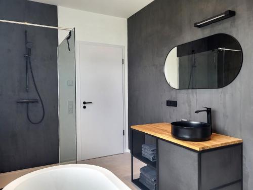a bathroom with a tub and a sink and a mirror at Ferienhaus Schlossterrassen 4a in Pouch