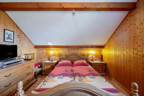 a bedroom with a large bed with wooden walls at Villa près du lac in Étercy