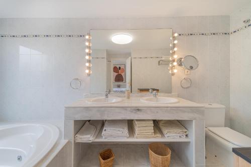 a bathroom with two sinks and a tub and a mirror at Pareado Relax in Marbella