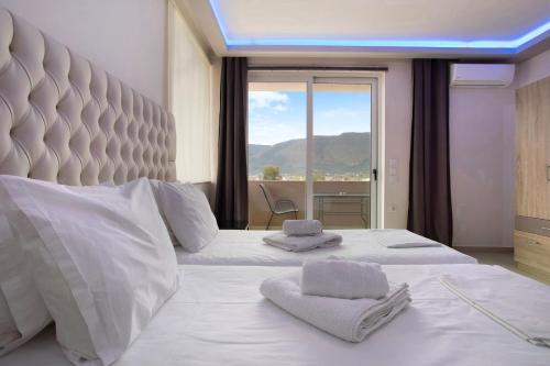 a bedroom with two beds and a large window at Villa Dionysia Apartment A2 in Alikanas