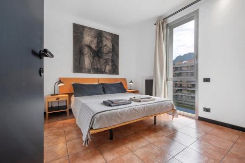 a bedroom with a bed and a large window at Lake Como Design Home in Lecco