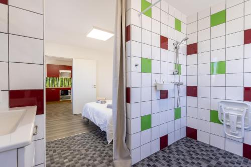 a bathroom with a shower and a bed in a room at L'ilot Narossais - Conciergerieland in Narrosse