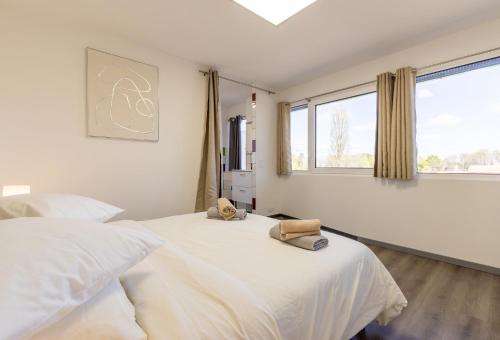 a bedroom with two beds and two windows at L'ilot Narossais - Conciergerieland in Narrosse