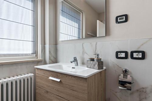 a bathroom with a sink and a mirror and a radiator at Villa Vacanze Renetta in Tuenno