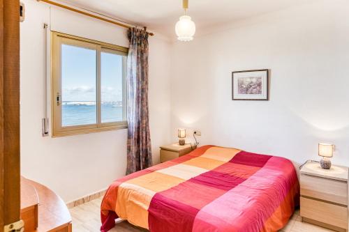 a bedroom with a large bed and a window at Platja Mar 3º in L'Escala