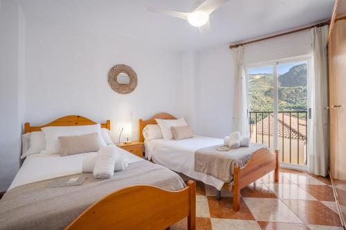 two beds in a room with a balcony at Casa Ramirez in Güéjar-Sierra
