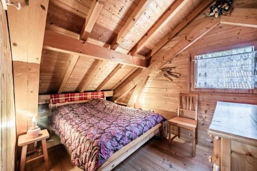 a bedroom with a bed in a log cabin at Chalet 6p Classique - Le Marmotton in Verchaix
