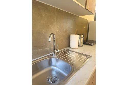 a stainless steel sink in the corner of a kitchen at Studio Episkopos in Nikiana