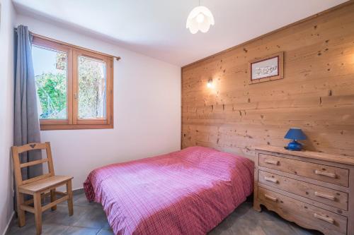 a bedroom with a bed and a wooden wall at La mouliniere 2 in Valloire