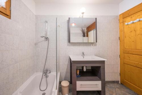 a bathroom with a shower and a tub and a sink at La mouliniere 2 in Valloire