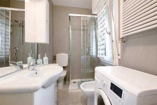 a bathroom with a sink and a washing machine at Casa Miki in Sarnico