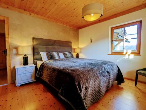 a bedroom with a large bed and a window at Chalet Sonnberg Bramberg in Bramberg am Wildkogel