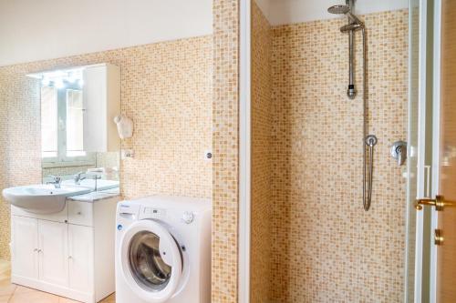 a bathroom with a washing machine and a shower at Aria in Follonica