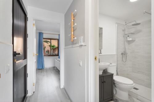 a white bathroom with a toilet and a sink at Horizon blu in Corralejo