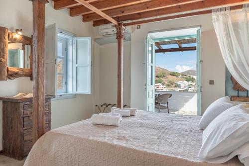 a bedroom with a large bed with towels on it at Santanna Suites in Patmos